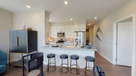 This thoughtfully designed single-floor residence offers a seamless blend of modern finishes and functional living spaces. The open-concept kitchen is a standout feature, showcasing granite countertops, white shaker cabinetry, a subway tile backsplash, and a full suite of stainless steel appliances including a gas range, microwave, dishwasher, and French door refrigerator. A peninsula with seating for four provides a casual dining and gathering space that connects effortlessly to the main living areas. Wood-look flooring runs throughout, adding warmth and continuity across the layout. A dedicated dining nook benefits from generous window exposure, filling the space with natural light and offering pleasant outdoor views. The living area is bright and versatile, with large windows that further enhance the airy feel of the room. The bedrooms are well-proportioned and serene, each featuring wood-look flooring and access to natural light. Two full bathrooms serve the residence — one with a tub-shower combination and neutral tile flooring, and the other featuring a sliding glass enclosed shower, granite vanity countertop, and white cabinetry. The overall design palette is neutral and contemporary, creating a clean, inviting atmosphere throughout.
