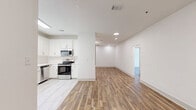 Located at 1300 Melody Lane in Valdosta, Georgia, this single-floor, 2-bedroom, 2-bathroom home offers a clean, modern aesthetic throughout. Warm wood-look flooring flows continuously through the living, dining, and bedroom spaces, complemented by crisp white walls and recessed lighting that create a bright, welcoming atmosphere.

The open-concept kitchen and dining area is a standout feature, showcasing white shaker-style cabinetry, a classic subway tile backsplash, light stone countertops, and a full suite of stainless steel appliances including a refrigerator, range, microwave, and dishwasher. Light tile flooring in the kitchen transitions seamlessly into the main living areas.

The spacious living room is open and airy, extending into the dining area for a connected, functional layout. Both bedrooms are generously proportioned, featuring wood-look flooring, ceiling fans, and double-door closets. The primary bedroom offers a comfortable amount of space and natural light through a window with blinds.

The bathrooms are finished with elegant marble-style tile surrounding the tub-shower combinations, paired with brushed nickel fixtures. A dedicated laundry room includes a full-size washer and dryer with overhead shelving. Additional storage is provided through closets and a utility room, completing this thoughtfully designed home.