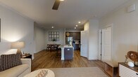 This single-floor residence at 2700 Whakatane Ln in Fuquay-Varina, NC offers a thoughtfully designed open-concept layout that connects the living, dining, and kitchen areas seamlessly. Rich hardwood-style flooring flows throughout the main living spaces, complemented by neutral wall tones and ceiling fans in every room.

The kitchen is equipped with dark gray cabinetry, granite-style countertops, a subway tile backsplash, stainless steel appliances including a range and refrigerator, and a central island with seating — ideal for both cooking and casual dining. Adjacent to the kitchen, the dining area features crown molding and a cozy nook perfect for intimate meals.

The living room is bright and welcoming, with large French doors that invite natural light and provide outdoor access. The primary bedroom offers plush carpeting, multiple windows with ample natural light, and a spacious walk-in closet with wire shelving. A secondary bedroom provides comfortable accommodations with its own ceiling fan. The bathrooms are designed with accessibility in mind, featuring grab bars and hardwood-style flooring. Crown molding and recessed lighting throughout add refined finishing touches to this well-appointed home.