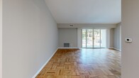 Located at 750 E Cathedral Rd in the Roxborough neighborhood of Philadelphia, this one-bedroom, one-bathroom residence offers a well-organized single-floor layout. The open living room is a standout space, featuring classic parquet hardwood flooring and expansive sliding glass doors that flood the room with natural light and provide direct views of lush greenery outside. The vaulted ceiling adds a sense of height and airiness, enhancing the spacious feel of the main living area. Louvered closet doors provide additional storage conveniently within reach of the living space. The kitchen is efficiently designed with warm oak cabinetry, granite-style laminate countertops, a stainless steel sink, and white appliances including a gas range, dishwasher, and refrigerator. Light tile flooring in the kitchen complements the hardwood found throughout the rest of the home. The generously sized bedroom features smooth hardwood floors, neutral gray walls, and a large window that allows ample natural light and outdoor views. A double-door closet provides substantial storage. The bathroom includes a full tub and shower combination with clean white tile surround. A hallway connects all rooms, maintaining a logical and practical flow throughout the residence.
