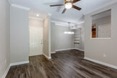 Located at 4778 Oak St in Kansas City, Missouri, this single-floor residence offers a well-appointed interior defined by consistent finishes and thoughtful design throughout. The main living area welcomes you with rich hardwood-style flooring, crown molding, and a ceiling fan with light fixture, creating a warm and polished atmosphere. Recessed lighting and a stylish pendant fixture in the dining area add to the refined ambiance. A pass-through window connects the living space to the kitchen, which is outfitted with white shaker-style cabinetry, light quartz countertops, a classic white subway tile backsplash, and stainless steel appliances including a range, microwave, and dishwasher. An arched hallway transitions gracefully to the private areas of the home. The bedroom features plush carpeting, crown molding, a ceiling fan, and an arched window that brings in natural light. A generously sized walk-in closet with wire shelving provides ample storage. The bathroom offers a clean, modern aesthetic with white cabinetry, quartz countertops, and brushed nickel hardware. Throughout the space, neutral tones and consistent trim work create a cohesive and inviting environment.