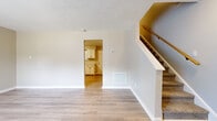 Located at 4333 Grove Ave in Winston-Salem, NC, this two-story, 3-bedroom, 1-bathroom home offers a clean and functional layout with modern finishes throughout. The main floor features a bright, open living room with light luxury vinyl plank flooring and a textured ceiling, flowing naturally into the kitchen through a wide doorway. The kitchen is well-appointed with white shaker-style cabinetry, light stone countertops, stainless steel appliances including a refrigerator and electric range, and matching vinyl plank flooring that ties the space together cohesively. A staircase with a wooden handrail connects the main level to the upper floor, where the bedrooms are located. The primary bedroom offers a comfortable footprint with its own closet, while the additional bedrooms feature plush carpeting and windows that invite natural light and views of the surrounding greenery. One bedroom includes light vinyl plank flooring for a versatile feel. The full bathroom includes a clean white tub-shower surround. Two closets provide ample storage throughout the home. Neutral warm-toned walls, consistent trim work, and thoughtful finishes give the entire home a move-in ready, well-maintained ambiance.