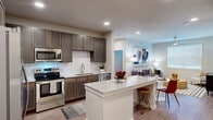 Located in Spring, Texas, this single-story 2-bedroom, 2-bathroom residence offers a thoughtfully designed open-concept layout. The kitchen is a standout feature, equipped with stainless steel appliances including a French door refrigerator, electric range, built-in microwave, and dishwasher. Rich dark-toned cabinetry pairs with a classic white subway tile backsplash and a granite-topped central island with bar seating, creating a functional and stylish space that flows seamlessly into the combined dining and living area. The living room is bright and welcoming, benefiting from natural light through large windows with blinds and a ceiling fan overhead. Wood-look plank flooring runs consistently throughout the home, adding warmth and cohesion. Both bedrooms are generously proportioned, each featuring ceiling fans with lighting and windows that allow natural light to fill the rooms. The primary bedroom connects to a walk-in closet with built-in wire shelving, offering ample storage. The bathrooms are cleanly finished, with one featuring a tub-shower combination accented by white subway tile surround. Additional closets provide further storage throughout the residence, completing this well-organized and modern home.
