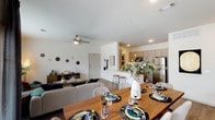 Located in Houston, TX (77396), this single-floor residence offers a thoughtfully designed open-concept layout that seamlessly connects the living, dining, and kitchen areas. The living room is bright and welcoming, featuring wood-style flooring, a ceiling fan, and large windows dressed with layered curtains that invite generous natural light and views of the surrounding outdoors. The dining area accommodates a full-sized dining table and is accented by a striking large-scale abstract wall painting, with glass French doors that further enhance the sense of openness and light. The kitchen is well-equipped with stainless steel appliances — including a refrigerator, electric range, and microwave — complemented by gray shaker-style cabinetry extending to the ceiling, granite countertops, and a breakfast bar with counter seating. The bedroom features wood-style flooring, a ceiling fan, large windows providing natural light, and ample wall space. The bathroom includes a soaking tub with subway tile surround. Recessed lighting and neutral wall tones throughout the space create a clean, modern aesthetic, while the cohesive use of warm wood tones and contemporary finishes gives the entire residence a polished, move-in-ready feel.