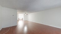 Located on Zelzah Avenue in Encino, Los Angeles, this two-story, 2-bedroom, 3-bathroom home offers a well-organized layout across two floors. The main level features a generously sized living room with rich hardwood flooring, a textured ceiling, and a large picture window that floods the space with natural light and offers views of the surrounding greenery. The kitchen is thoughtfully appointed with white shaker cabinetry, stainless steel appliances including a refrigerator, range, microwave, and dishwasher, white countertops, and a ceiling fan for added comfort. A secondary dining or flex area adjacent to the kitchen provides additional versatility. The bathrooms are clean and functional, with one featuring a sliding-door enclosed shower stall and tile flooring. Upstairs, the bedrooms are carpeted and well-lit, with the spacious primary bedroom offering ample room and a bright window. The second bedroom is similarly comfortable with a wide horizontal window and soft carpet throughout. The home's neutral white walls and consistent hardwood and carpet flooring create a cohesive, clean aesthetic throughout, making it a functional and comfortable residence in a convenient Los Angeles neighborhood.