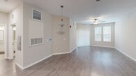 Located at 2775 Red Apple Cir in Kissimmee, FL, this one-bedroom, one-bathroom residence offers a well-designed single-floor layout that maximizes functionality and comfort. The open living area features durable hardwood-style flooring, a ceiling fan, and generous natural light streaming through large windows with sliding glass door access, creating a bright and welcoming atmosphere.

The kitchen is a standout feature, showcasing crisp white shaker-style cabinetry, granite countertops, a subway tile backsplash, and a full suite of stainless steel appliances including a refrigerator, dishwasher, microwave, and electric range. Track lighting overhead adds both style and practicality to the space.

The bedroom is finished with plush carpeting and benefits from dual windows that invite natural light and greenery views. A dedicated closet provides convenient storage. The bathroom is clean and modern, featuring wood-look tile flooring, a tub-shower combination with white tile surround, granite countertops, and white cabinetry. Neutral tones and clean finishes are carried throughout the home, contributing to a cohesive and move-in-ready aesthetic. This well-appointed residence offers comfortable Florida living in a compact, efficient layout.