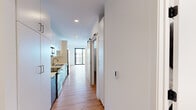 Located in Milwaukee's vibrant Upper East Side neighborhood, this contemporary 1-bedroom, 1-bathroom unit offers a well-designed layout with modern finishes throughout. Warm-toned hardwood-style flooring flows seamlessly across the entire space, complementing the crisp white walls and creating a clean, cohesive aesthetic.

The open-concept kitchen and living area serves as the heart of the unit. The kitchen is outfitted with stainless steel appliances — including a range, over-the-range microwave, and dishwasher — paired with sleek two-tone cabinetry featuring gray lower cabinets and white upper cabinets, white quartz countertops, a subway tile backsplash, and a stainless steel sink. The adjacent living room benefits from abundant natural light and provides direct access to a private balcony through floor-to-ceiling sliding glass doors, offering elevated views of the surrounding Milwaukee cityscape.

The bedroom is a well-proportioned retreat with its own walk-in closet, complete with built-in shelving for organized storage. A stylish barn door adds a contemporary architectural detail to the space. The full bathroom features a clean, all-white design with a soaking tub/shower combo, a floating vanity, and recessed lighting. The overall ambiance is modern, bright, and move-in ready.
