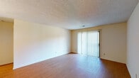 Located at 4923 Lakeside Ct in Evansville, Indiana, this single-floor residence offers a practical and comfortable layout with a clean, neutral aesthetic throughout. The living area is bright and open, featuring warm wood-look flooring and a large sliding glass door dressed with vertical blinds that allows abundant natural light to fill the space. A chandelier-lit hallway connects the main living area to the rest of the home, creating a welcoming flow between rooms. The galley-style kitchen is well-equipped with rich, dark wood cabinetry, light laminate countertops, a stainless steel sink, and tile flooring, providing efficient use of space with ample storage and counter room. The bedrooms are carpeted for comfort, featuring textured ceilings and natural light from windows with horizontal blinds that offer outdoor views of the surrounding greenery. The bathroom is thoughtfully appointed with a single-sink vanity featuring cream cabinetry, a large mirror with overhead lighting, a tub-shower combination, and tile flooring, maintaining a tidy and functional design. Throughout the home, textured ceilings and neutral wall tones create a consistent, understated palette that is move-in ready and easy to personalize.