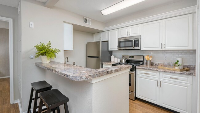 Relish gleaming kitchens with subway tile backsplash and white cabinetry for a modern touch. - The Enclave at Huntington Woods