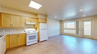 Located at 150 E Avenue R in Palmdale, CA, this single-story, 3-bedroom, 2-bathroom residence offers a thoughtfully organized layout across one floor. Light wood-style flooring runs consistently throughout, lending a clean, cohesive look to every room.

The kitchen is a functional highlight, featuring warm light-wood cabinetry extending to the upper walls for generous storage, white appliances including a refrigerator, electric range, and dishwasher, and a skylight that fills the space with natural light. The kitchen opens to a combined living area, creating a practical and connected common space.

The three bedrooms are well-proportioned, each finished with the same wood-style flooring and neutral warm-toned walls. The primary bedroom offers dedicated closet space and access to the hallway. Secondary bedrooms feature large windows that bring in natural light and offer views of the surrounding Palmdale landscape, including outdoor greenery and open terrain. Two hallways connect the bedroom wing to the main living areas, supporting a logical flow throughout the home.

Both bathrooms are finished consistently, each equipped with a full soaking tub and shower combination, wood-style flooring, and accessibility grab bars, making the space practical and functional. Recessed lighting and ceiling ventilation are present throughout, contributing to a bright and well-maintained interior.