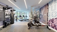 Located at 195 River Grove Way in West Palm Beach, Florida, this contemporary fitness center is a well-appointed, single-floor facility designed to support a comprehensive range of workout routines. The space is defined by its clean, modern aesthetic, with bright white walls, neutral-toned carpet flooring, and sleek linear LED lighting that runs across the ceiling to create an energetic yet focused atmosphere.

The main workout area is generously proportioned and houses an impressive array of cardio equipment, including multiple treadmills, elliptical trainers, stair climbers, stationary bikes, and an Assault air bike and rowing machine. A dedicated strength training zone features a multi-station cable machine, selectorized weight machines, and free weight benches. Floor-to-ceiling mirrors are positioned throughout, visually expanding the space and providing functional support during workouts.

Large black-framed windows line the perimeter, flooding the interior with natural light and offering views of the surrounding greenery. Bold, large-scale motivational murals serve as striking design accents, adding visual energy to the environment. A separate studio room features light hardwood flooring, mirrored walls, built-in storage cabinetry, and a large-screen television, making it well suited for group fitness classes or personal training sessions.