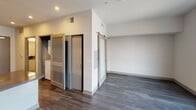 Located at 11920 W Pico Blvd in the heart of West Los Angeles, this modern single-floor unit offers a thoughtfully designed layout with clean, contemporary finishes throughout. The kitchen serves as a functional centerpiece, featuring a full suite of stainless steel appliances including a gas range, over-the-range microwave, side-by-side refrigerator with ice and water dispenser, and dishwasher. White flat-panel cabinetry with sleek hardware extends to the ceiling, maximizing storage, while dark countertops and a geometric-patterned tile backsplash add visual depth. Under-cabinet lighting enhances both ambiance and utility. Dark hardwood-style flooring flows through the main living areas, offering a warm contrast to the bright white walls. A sliding barn door adds a modern architectural touch while optimizing the use of space. The bedroom benefits from large windows that frame views of the surrounding West LA neighborhood and distant hills, filling the room with natural light. The bathroom is finished with matching white cabinetry, a dark countertop vanity, a large mirror with overhead lighting, and light-toned tile flooring, creating a clean and cohesive aesthetic. The overall design reflects a modern urban sensibility, combining practical functionality with contemporary style in a well-connected Los Angeles location.