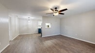 This single-story, 2-bedroom, 2-bathroom residence offers a thoughtfully designed layout that maximizes functionality and comfort. The open-concept living and dining area serves as the heart of the home, featuring rich wood-look flooring, neutral walls, and a ceiling fan with integrated lighting. A pass-through window connects the living area to the kitchen, enhancing the sense of openness throughout.

The kitchen is a standout space, showcasing two-tone cabinetry with navy blue lower cabinets and crisp white upper cabinets, complemented by white quartz countertops and a classic subway tile backsplash. Stainless steel appliances, including a refrigerator, range, microwave, and dishwasher, complete the modern aesthetic. A decorative pendant light adds a stylish finishing touch.

Both bedrooms are carpeted for comfort and include ceiling fans and windows fitted with blinds that allow natural light to filter in. The primary bedroom offers a generous footprint, providing ample space for furnishings.

The bathrooms continue the navy and white design theme, featuring matching cabinetry, white countertops, large mirrors, and wood-look tile flooring. A hallway connects the main rooms, contributing to a practical and efficient floor plan throughout the home.