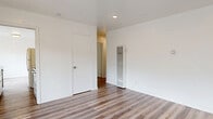 Located at 1634 Milvia St in Berkeley, CA, this single-floor, 3-bedroom, 1-bathroom unit offers a well-organized layout across a compact but functional footprint. Warm-toned vinyl plank flooring runs consistently throughout the space, lending a clean and cohesive aesthetic to every room.

The bright living room serves as the heart of the unit, featuring recessed lighting and a sliding glass door that opens onto a private balcony, filling the space with natural light and providing views of the surrounding greenery. Adjacent to the living room, the galley-style kitchen is efficiently designed with white cabinetry, a marble-look tile backsplash, light quartz countertops, stainless steel appliances, and a full-size refrigerator — maximizing both style and storage.

The three bedrooms are well-proportioned, each with white walls and ample closet space — five closets are distributed throughout the unit in total. Several bedrooms feature windows with blinds that allow for natural light and privacy. The primary bedroom includes a wall-mounted heater unit for individual climate control.

The bathroom is finished with classic white hex tile flooring, marble-surround shower walls, and brushed gold fixtures, offering a refined, timeless look. A separate dining area completes the layout, making this a fully functional and thoughtfully appointed Berkeley home.