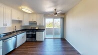 Located at 201 E 12th St, Unit C in Oakland, CA, this single-floor apartment offers a thoughtfully designed living space with a clean, modern aesthetic throughout. Rich, dark hardwood-style flooring flows seamlessly across the main living areas, creating a warm and cohesive look.

The kitchen is well-appointed with white shaker cabinetry, dark granite countertops, and stainless steel appliances, including a gas range and a full-size refrigerator. A sliding glass door off the kitchen leads to a private balcony that captures sweeping views of the Oakland skyline and surrounding greenery, filling the space with abundant natural light. A ceiling fan overhead keeps the area comfortable year-round.

The living area is generously proportioned, featuring clean walls and large windows that invite additional natural light and neighborhood views. The bedroom includes a spacious walk-in closet with full-width shelving and a rod for ample storage, along with a window framing pleasant outdoor scenery.

The bathroom is finished with a white vanity, a light stone countertop, a large mirror with overhead lighting, and a full bathtub with a showerhead, all set against durable hardwood-style flooring. The unit's warm neutral tones and updated finishes throughout create a comfortable and inviting atmosphere in the heart of Oakland.