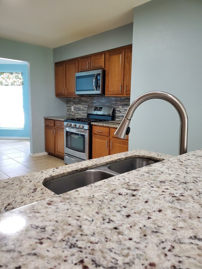Kitchen has granite countertops and tile backsplash. Stainless steel appliances. - 1842 Tomlinson Trail Dr