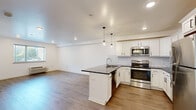 Located at 6649 Ridge Avenue in Philadelphia's Roxborough neighborhood, this thoughtfully designed one-bedroom, one-bathroom unit offers a clean, modern aesthetic across a single floor. The open-concept layout seamlessly connects the kitchen and living room, maximizing the efficient use of space. The kitchen is a standout feature, showcasing white shaker-style cabinetry, dark granite countertops, a classic subway tile backsplash, and a full suite of stainless steel appliances including a refrigerator, range, and microwave. A peninsula with pendant lighting provides additional prep space and serves as a natural divider between the kitchen and the open living area. Light wood-tone flooring runs throughout the unit, lending warmth and cohesion to each room. The living room benefits from natural light through a large window with outdoor views, and includes a wall-mounted HVAC unit. The bedroom is a comfortable, well-proportioned retreat with a double-door closet, light walls, and the same wood-tone flooring. The bathroom is elegantly appointed with a glass-enclosed marble-tiled shower, a gray vanity with a white countertop, and wood-look tile flooring, completing this polished and move-in-ready home.
