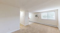 Located at 17 W Vine St in Pottstown, PA, this one-bedroom, one-bathroom unit offers a practical and well-organized layout across a single floor. The living area is finished with wall-to-wall carpeting and neutral cream-toned walls, creating a clean, understated aesthetic. Natural light filters through blinded windows, and baseboard heating along with a wall-mounted AC unit provide year-round climate comfort. The kitchen is efficiently designed with warm maple cabinetry, dark granite-style countertops, and tile flooring. It comes equipped with a full suite of black appliances, including a refrigerator, dishwasher, microwave, and a range, along with a window that brightens the space. The spacious bedroom features soft carpeting, a wide mirrored sliding-door closet that enhances the sense of space, a window with natural light, and baseboard heating. The bathroom is finished with large-format neutral tiles on both the floor and walls, a built-in shower, a single vanity with storage, and a lighted mirror. A dedicated closet provides additional storage within the unit. Overall, the space presents a clean, move-in-ready environment suited for comfortable everyday living.