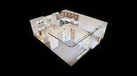 This 560-square-foot, one-bedroom, two-bathroom apartment at 201 8th Avenue Northwest in Austin, MN offers a well-planned modern layout across a single floor. The combined kitchen and living area features light hardwood-style flooring, recessed lighting, and an open design that maximizes the use of space. The kitchen is equipped with stainless steel appliances — including a refrigerator, electric range, microwave, and dishwasher — complemented by rich walnut-toned cabinetry and light countertops. The 130-square-foot bedroom is carpeted for comfort and includes direct access to a dedicated closet, with views to the outdoors through a large window. The living area opens to a private balcony through sliding glass doors, bringing in natural light and outdoor views. Exposed ductwork adds an industrial design element throughout the unit. The two bathrooms are finished with warm wood vanities, white countertops, large rectangular mirrors, and sleek matte black fixtures. One bathroom features a clean, all-white shower enclosure with a built-in niche. The unit combines modern aesthetics with functional living in a compact, efficient footprint.