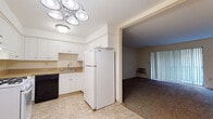 Located at 44 Brittany Farms Rd in New Britain, Connecticut, this single-floor residence offers a practical and well-organized layout across its living areas. The kitchen is outfitted with white cabinetry, a gas range, a full-size refrigerator, a black dishwasher, and a sink with ample counter space. Tile flooring and overhead lighting with multiple recessed fixtures give the kitchen a clean, functional aesthetic. It opens directly into the living area, creating a connected and accessible flow.

The living room is generously proportioned, featuring wall-to-wall carpet, baseboard heating, and a sliding glass door dressed with vertical blinds that allows natural light to fill the room. A wall-unit air conditioner provides additional climate control. The space feels open and versatile, well-suited for a variety of furniture arrangements.

The bedroom is spacious and carpeted, with a large window overlooking greenery outdoors. A standout feature is the dual set of louvered bifold closet doors, offering substantial built-in storage. Baseboard heating runs along the perimeter, and a built-in shelving unit is visible from the adjoining hallway area.

The bathroom is finished with warm-toned tile flooring, a tiled tub and shower surround, and a white vanity. The overall palette throughout the residence is neutral and bright, contributing to a clean, move-in-ready atmosphere.