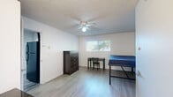 Located at 1863 Kincaid St in Eugene, Oregon, this efficient single-floor unit offers 1 bedroom and 2 bathrooms within a well-utilized layout. Light wood-look flooring runs throughout, lending a clean and cohesive look to the entire space.

The kitchen is compact yet functional, featuring a black electric range with an over-the-range microwave, a single-basin sink, and a window that allows natural light to brighten the area. The open corridor connects the kitchen seamlessly to the combined living and dining area, which provides flexible use of the shared space.

The bedroom is the largest room in the unit, offering a comfortable footprint with a ceiling fan, a window with blinds that brings in natural light, and clean white walls. An in-room vanity with blue cabinetry, a mirrored medicine cabinet, and a sink adds a unique and practical touch directly within the bedroom space.

Two bathrooms serve the unit, one of which features a tiled shower-tub combination with a window that adds ventilation and light, complemented by wood-look flooring for a consistent aesthetic.

Throughout the unit, textured ceilings and crisp white walls create a bright, neutral backdrop. The straightforward layout and practical finishes make this a highly functional space suited for efficient everyday living.
