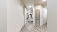 Located at 2707 Anderson Gibson Rd in Grapevine, TX, this single-story, 3-bedroom, 2-bathroom home offers a well-designed layout with modern finishes throughout. Light-toned wood-look flooring runs through the main living areas, complemented by neutral walls that create a bright, clean aesthetic. The open-concept kitchen serves as the heart of the home, featuring white cabinetry, dark granite countertops, a center island with pendant lighting, stainless steel appliances including a refrigerator, microwave, and range, plus a dedicated pantry for additional storage. Track lighting adds a contemporary touch overhead. The living area is bathed in natural light from large windows and includes a ceiling fan and direct access to the exterior via a glass-paned door. The generously sized primary bedroom features plush carpet and connects to a private bathroom equipped with a granite-topped vanity, white cabinetry with matte black hardware, and a walk-in shower with a glass door. Two additional carpeted bedrooms offer natural light from individual windows. A second full bathroom mirrors the same quality finishes. The dedicated laundry room houses a full-size washer and dryer. With four closets providing ample storage, this home blends functionality with modern style in a convenient Grapevine location.