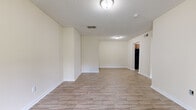 Located at 2537 Thomas Ln in Augusta, Georgia, this single-floor home offers a clean, functional layout with consistent light wood-look flooring throughout. The spacious living area is open and bright, featuring neutral cream-toned walls, white baseboards, and a textured ceiling. Recessed vents and flush-mount lighting fixtures are present throughout, contributing to a practical and well-maintained interior.

The kitchen is equipped with warm medium-toned wood cabinetry, granite-patterned countertops, a single-basin sink, and black appliances including an electric range with overhead ventilation. The kitchen connects naturally to the main living space, supporting an efficient flow through the home.

The bedrooms are comfortably sized, each featuring the same wood-look flooring and neutral walls. One bedroom includes a closet accessible through a paneled door, while another benefits from a window with views of surrounding greenery, allowing natural light to fill the room. The front entry area also includes a window that brings in additional daylight.

The bathroom is straightforward and functional, featuring a tub-shower combination with a surround panel, a toilet, a vanity with storage, and the same wood-look flooring found throughout the home. Overall, the space presents a clean, move-in ready environment with a cohesive aesthetic throughout.