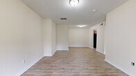 Located at 2537 Thomas Ln in Augusta, Georgia, this single-floor home offers a clean, functional layout with consistent light wood-look flooring throughout. The spacious living area is open and bright, featuring neutral cream-toned walls, white baseboards, and a textured ceiling. Recessed vents and flush-mount lighting fixtures are present throughout, contributing to a practical and well-maintained interior.

The kitchen is equipped with warm medium-toned wood cabinetry, granite-patterned countertops, a single-basin sink, and black appliances including an electric range with overhead ventilation. The kitchen connects naturally to the main living space, supporting an efficient flow through the home.

The bedrooms are comfortably sized, each featuring the same wood-look flooring and neutral walls. One bedroom includes a closet accessible through a paneled door, while another benefits from a window with views of surrounding greenery, allowing natural light to fill the room. The front entry area also includes a window that brings in additional daylight.

The bathroom is straightforward and functional, featuring a tub-shower combination with a surround panel, a toilet, a vanity with storage, and the same wood-look flooring found throughout the home. Overall, the space presents a clean, move-in ready environment with a cohesive aesthetic throughout.