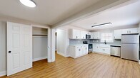 Located at 403 Holly Ln in Dothan, Alabama, this 2-bedroom, 1-bathroom unit offers a thoughtfully updated interior with a clean, modern aesthetic. Warm hardwood-style flooring flows throughout every room, creating a cohesive and inviting atmosphere.

The kitchen is a standout feature, showcasing crisp white shaker cabinets with matte black hardware, light quartz countertops, a classic farmhouse sink, and a gray subway tile backsplash. A full suite of stainless steel appliances — including a refrigerator, dishwasher, gas range, and built-in microwave — completes this functional and stylish space. Natural light filters in through multiple windows with blinds.

Both bedrooms are comfortably sized, each featuring a dedicated closet with a hanging rod. The primary bedroom includes a ceiling fan and a bright window with an exterior view. The secondary bedroom benefits from a central overhead light fixture and offers a quiet, neutral palette.

The bathroom is clean and well-finished, with a tiled tub-and-shower surround in coordinating gray tones and matte black fixtures and accessories that echo the design language found throughout the unit.

A hallway connects the living areas to the bedrooms, and the spacious living room provides a welcoming common area. The unit offers practical, move-in-ready living with contemporary updates throughout.