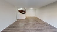Located at 312 Quail Dr in Hobart, Indiana, this single-floor unit offers a clean, functional layout designed for comfortable everyday living. The open-concept living and dining area is finished with durable wood-look flooring throughout, creating a bright and cohesive feel. A pass-through window connects the living space to the kitchen, maintaining an open and communicative floor plan. The kitchen is well-appointed with rich dark espresso cabinetry, light granite-style countertops, a stainless steel refrigerator, a black gas range, and a stainless steel sink — providing ample storage and workspace. Sliding glass doors in the living area open to an outdoor view, bringing in natural light and providing convenient outdoor access. The bedrooms are carpeted for added comfort and feature large windows that allow natural light to filter in. The full bathroom is outfitted with a dark vanity consistent with the kitchen cabinetry, wood-look tile flooring, and a full tub-shower combination. Built-in shelving near the bathroom offers additional storage. The unit presents a cohesive, updated aesthetic throughout with neutral tones and modern fixtures, making it a practical and move-in-ready space.