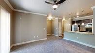 Located at 8515 Clearwater Ln in Indianapolis, IN, this well-appointed one-bedroom, one-bathroom unit offers a thoughtfully designed single-floor layout. The kitchen serves as a central highlight, featuring dark espresso cabinetry, granite countertops, stainless steel appliances including a refrigerator, microwave, and range, as well as a peninsula island with a double-basin sink illuminated by elegant pendant lighting. Track lighting adds a modern touch to the kitchen's ceiling, which is also adorned with crown molding that carries throughout the main living areas. The open living area flows naturally from the kitchen, finished with plush carpet and a ceiling fan. The generously sized primary bedroom offers natural light through a large window with blinds and is also fitted with a ceiling fan. The full bathroom includes a soaking tub with tile surround, granite vanity countertop, dark cabinetry, and hardwood-style flooring. A dedicated laundry room houses a full-size side-by-side washer and dryer on hardwood-style flooring. A closet provides additional storage. Neutral warm-gray walls, white trim, and consistent finishes unify the space with a clean, cohesive aesthetic throughout.