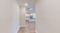 This single-story, 3-bedroom, 2-bathroom home offers a bright and modern living experience highlighted by clean lines and quality finishes throughout. The open-concept kitchen and living area serves as the heart of the home, anchored by a spacious center island with a granite countertop, undermount sink, and stylish pendant lighting. White shaker-style cabinetry lines the kitchen walls, complemented by a subway tile backsplash and a full suite of stainless steel appliances, including a French door refrigerator, range, microwave, and dishwasher. Light-toned hardwood-style flooring flows seamlessly through the main living areas, enhancing the airy, cohesive feel of the space. The bedrooms are carpeted for comfort and each features natural light from double windows with blinds and ceiling fans. The primary bedroom includes a walk-in closet outfitted with wire shelving for organized storage. Both bathrooms echo the home's consistent design language, featuring granite-topped vanities with white cabinetry, large mirrors, and hardwood-style flooring. A neutral color palette of warm whites and soft beiges ties every room together, creating a welcoming and move-in-ready environment. Recessed lighting throughout ensures the space remains well-lit and inviting.