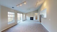 This single-floor residence at The Point at Pine Ridge in Coram, New York offers a well-designed layout with a seamless flow between living spaces. The expansive living and dining area is finished with soft, plush carpeting and neutral-toned walls, creating a bright and welcoming atmosphere. Large windows allow generous natural light to fill the space, with views of the surrounding greenery and community grounds.

The kitchen is equipped with ample white cabinetry, a gas range, an over-the-range microwave, and light-toned countertops with a tile backsplash, providing a clean and functional workspace.

The bedrooms are generously proportioned, each featuring wall-to-wall carpeting, neutral painted walls, and large windows that invite natural light and outdoor views. One bedroom includes a walk-in closet, adding practical storage.

The primary bathroom features a dual-sink vanity with white cabinetry, tile flooring, a well-lit mirror, and a separate closet area. A second full bathroom provides a single-sink vanity, tile flooring, a toilet, and a shower/tub combination, maintaining a consistent clean aesthetic throughout.

Overall, the residence presents a comfortable and functional living environment with a cohesive neutral palette, plentiful natural light, and thoughtful use of space throughout every room.