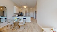 This single-story residence at 1200 Bridgeport Way in Suffolk, Virginia offers a well-designed, open-concept layout that seamlessly connects the kitchen, dining, and living areas. The kitchen is outfitted with white cabinetry, granite countertops, and a full suite of stainless steel appliances, including a gas range, built-in microwave, refrigerator, and dishwasher. Pendant lighting above the kitchen island adds a refined touch, while wood-look flooring anchors the space with warmth and durability.

The open dining area accommodates a table with ease, flowing naturally into the carpeted living room, which features neutral walls and ample space for relaxing or entertaining. A window at the far end of the living area allows natural light to brighten the interior throughout the day.

The bedrooms are carpeted and well-proportioned, each benefiting from natural light through blinded windows. At least one bedroom includes a walk-in closet with built-in shelving. The bathroom features a full tub-shower combination with hardwood-style flooring. The overall aesthetic is clean, contemporary, and cohesive, with a neutral palette throughout.