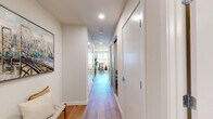 Located at 1702 Pacific Ave in Everett, Washington, this well-appointed one-bedroom, one-bathroom residence offers a thoughtfully designed layout across a single floor. Warm hardwood-style flooring flows throughout, unifying each space with a clean, contemporary aesthetic.

The open-concept kitchen and living area serves as the heart of the home. The kitchen features wood-grain cabinetry extending to the ceiling, white quartz countertops, a subway tile backsplash, and a full suite of stainless steel appliances, including a range, microwave, dishwasher, and French door refrigerator. A bar-height island provides additional prep and dining space.

The living room is bright and inviting, benefiting from large floor-to-ceiling windows that flood the space with natural light and offer expansive views of the surrounding Everett cityscape. A welcoming entryway hallway connects the main living area to the private quarters.

The bedroom is a calm retreat with a sliding closet, warm neutral tones, and continued hardwood-style flooring. The bathroom is elegantly elongated, featuring a wood-grain vanity with a white countertop, a large mirror, and a glass-enclosed walk-in shower. The overall design is modern, cohesive, and move-in ready.