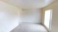 This two-floor residential space presents a clean, minimalist aesthetic throughout. The interior is characterized by smooth white walls and light neutral tones that create a bright, airy atmosphere, allowing natural light to reflect evenly across each room. Soft, wall-to-wall carpeting in a warm beige hue runs underfoot, adding comfort and a sense of continuity to the living areas. The open layout of the main living space is spacious and versatile, with clean lines and uncluttered surfaces that make it easy to envision a wide variety of furniture arrangements and design styles. The ceilings are smooth and generously proportioned, enhancing the sense of openness throughout. Subtle architectural details, such as defined wall transitions and recessed corners, provide quiet structure without overwhelming the space. The two-floor layout offers natural separation between living and private areas, lending the home a functional flow. Overall, the space exudes a calm, neutral ambiance — a well-maintained, move-in ready environment that serves as an ideal foundation for any interior design vision.