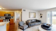 This thoughtfully designed 2-bedroom, 1-bathroom residence is laid out on a single floor, offering a functional and comfortable living environment. The open-concept living room and kitchen area form the heart of the home, bathed in natural light from a large sliding glass door that opens to an outdoor view of green surroundings. The living room features warm hardwood flooring, neutral wall tones, and ample space for relaxed seating arrangements.

The kitchen is well-equipped with warm wood cabinetry, granite countertops, a stone tile backsplash, and black appliances including a range, dishwasher, and refrigerator. A track lighting fixture and flush-mount ceiling light illuminate the space effectively.

The primary bedroom is a generously sized retreat with hardwood floors, a bright window overlooking the outdoors, and direct access to a dedicated closet outfitted with wire shelving for organized storage. The second bedroom offers similar comfort and natural light.

The full bathroom features a granite-topped vanity with wood cabinetry, a shower/tub combination, and tile flooring, maintaining a cohesive design aesthetic throughout. Clean white walls and consistent finishes tie the entire residence together, creating a bright, practical, and inviting home.