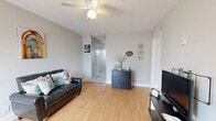 This well-utilized 2-bedroom, 1-bathroom single-floor residence offers a thoughtfully organized layout that maximizes every square foot. The living room serves as the heart of the home, featuring warm bamboo-style hardwood flooring, a ceiling fan with light fixture, and a window that brings in natural light. Neutral gray walls throughout create a clean, cohesive aesthetic.

The kitchen is outfitted with dark espresso cabinetry, a tile backsplash, stainless steel dishwasher, and light ceramic tile flooring. A secondary door in the kitchen provides additional access and extra natural light. The space also includes two pantry areas, adding generous storage capacity.

The primary bedroom offers carpet flooring and a window with natural light, while the second bedroom mirrors a similar layout with soft carpet and its own window. Both rooms maintain a calm, neutral palette. Three closets distributed throughout the unit provide practical storage solutions.

The bathroom features a full tub-shower combination with a clean, white surround. A connecting hallway ties the rooms together efficiently. Overall, the residence presents a functional, low-maintenance living environment with consistent finishes and a bright, open feel throughout.