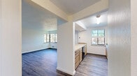 Located at 1433 W 9th Ave in Spokane, WA, this one-bedroom, one-bathroom unit offers a well-organized layout with wood-style flooring running throughout the entire space. The open living room is generously proportioned, featuring multiple windows that invite abundant natural light and frame views of surrounding greenery. A textured ceiling and wall-mounted air conditioning unit add functional character to the living area.

The kitchen is efficiently designed with light wood cabinetry, tile-accented countertops, and black appliances including a refrigerator, electric range, and dishwasher. A window above the sink brings in natural light, while a connected counter peninsula creates a natural transition to the living space.

The bedroom is a comfortable, well-lit room with a ceiling fan, a large window overlooking lush trees, and direct access to the bathroom. Clean white walls and wood-style flooring carry throughout, creating a cohesive look. A hallway with closet storage connects the bedroom to the rest of the unit.

The bathroom features a full tub and shower combination accented with earthy square tile detailing along the surround, complemented by warm wood-toned cabinetry at the vanity. Overall, the unit presents a clean, functional living environment with consistent finishes throughout.