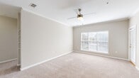 Located along U.S. 98 in Pensacola, Florida, this single-story 2-bedroom, 2-bathroom residence offers a well-organized layout designed for comfortable living. The galley-style kitchen is a standout feature, showcasing white cabinetry, dark granite-style countertops, black appliances including a refrigerator, range, and dishwasher, and a stainless steel sink — all set atop durable wood-look plank flooring. A curved breakfast bar peninsula connects the kitchen to the open living area, which transitions to plush neutral carpeting. The living space benefits from natural light and is finished with crown molding and a ceiling fan with light kit. Both bedrooms are generously proportioned, carpeted, and equipped with ceiling fans. Each room features large windows with blinds that allow ample natural light. The primary bedroom includes access to a dedicated closet. The secondary bedroom is similarly sized with its own closet access. A hallway connects the main living areas to the bedrooms and bathrooms. Both bathrooms feature tub/shower combinations with white tile surrounds and chrome fixtures, with one bathroom including dark countertop vanity and wood-look flooring. Additional storage is provided by a pantry and multiple closets throughout.