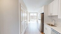 Located at 30 W Broad St in Bethlehem, PA, this thoughtfully designed one-bedroom, one-bathroom unit offers a clean, modern aesthetic throughout. Light hardwood flooring flows seamlessly across the open layout, complemented by a neutral color palette that enhances the sense of brightness and space.

The kitchen is well-appointed with white shaker-style cabinetry, quartz countertops, a classic subway tile backsplash, and a full suite of stainless steel appliances including a refrigerator, electric range, dishwasher, and over-the-range microwave. A single-basin sink with a modern faucet completes the functional workspace.

The living area receives generous natural light through large windows that frame views of the surrounding Bethlehem streetscape. A wall-mounted mini-split system provides efficient climate control. The bedroom is a comfortable size, featuring oversized windows that flood the room with sunlight and a stylish sliding barn door that adds a contemporary design touch. A dedicated closet provides practical storage.

The bathroom is finished with large-format tile flooring, a white vanity with an undermount sink and a mirror with modern light fixtures above, offering a clean and polished feel. The unit's efficient layout makes excellent use of every square foot, making it a practical and attractive option in downtown Bethlehem.