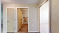 Located at 1705 S Hayford Rd in Airway Heights, WA, this one-bedroom, one-bathroom unit offers a practical and well-organized single-floor layout. The combined kitchen and living area forms the heart of the home, featuring light wood cabinetry, dark countertops, a white range, and durable wood-look flooring throughout. A pass-through counter connects the kitchen to the living space, creating an open feel. Natural light filters in through windows fitted with horizontal blinds, brightening the neutral-toned walls. The living area is carpeted and includes a wall-mounted air conditioning unit and a floor vent for year-round comfort. The bedroom is a comfortable, carpeted retreat with a window overlooking greenery outside, providing a peaceful atmosphere. A dedicated closet offers convenient storage adjacent to the bedroom. The full bathroom is finished with wood-look flooring, a vanity with light wood cabinetry, a soaking tub, and accessibility-friendly grab bars along the walls. Clean white trim and soft neutral paint tones carry throughout the unit, lending a cohesive and understated aesthetic. This unit is a straightforward, functional residence well-suited for those seeking an efficient and comfortable living space.