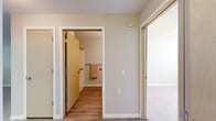 Located at 1705 S Hayford Rd in Airway Heights, WA, this one-bedroom, one-bathroom unit offers a practical and well-organized single-floor layout. The combined kitchen and living area forms the heart of the home, featuring light wood cabinetry, dark countertops, a white range, and durable wood-look flooring throughout. A pass-through counter connects the kitchen to the living space, creating an open feel. Natural light filters in through windows fitted with horizontal blinds, brightening the neutral-toned walls. The living area is carpeted and includes a wall-mounted air conditioning unit and a floor vent for year-round comfort. The bedroom is a comfortable, carpeted retreat with a window overlooking greenery outside, providing a peaceful atmosphere. A dedicated closet offers convenient storage adjacent to the bedroom. The full bathroom is finished with wood-look flooring, a vanity with light wood cabinetry, a soaking tub, and accessibility-friendly grab bars along the walls. Clean white trim and soft neutral paint tones carry throughout the unit, lending a cohesive and understated aesthetic. This unit is a straightforward, functional residence well-suited for those seeking an efficient and comfortable living space.