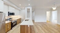 Located at 100 Starwood Dr in Guelph, Ontario, this modern 3-bedroom, 2-bathroom unit spans 92 square meters across a single floor. Light hardwood flooring flows throughout, complementing a clean, neutral colour palette that gives the entire space a bright and airy feel. The open-concept kitchen and living area serves as the heart of the unit, featuring a large island with a white quartz countertop and undermount sink, two-tone cabinetry combining white upper cabinets with warm wood lower cabinets, and a full suite of stainless steel appliances including a refrigerator, electric range, and built-in microwave. Recessed lighting illuminates the kitchen area. The living room is spacious and well-lit, with a sliding glass door that opens to a balcony overlooking the surrounding neighbourhood. The primary bedroom measures 15 square meters and includes a tray ceiling detail and a large window with neighbourhood views. Additional bedrooms are bright with large windows and ample space. The two bathrooms are finished with white subway tile; one features a frameless glass walk-in shower with brushed nickel fixtures, while the other offers a full soaker tub with an overhead shower. The unit also includes an entrance and a dedicated closet, rounding out a functional and well-appointed layout.