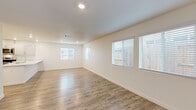 Located at 2000 Rydal Cir in Roseville, CA, this two-story home offers four bedrooms and five bathrooms across two well-proportioned floors. The main level houses the open-concept living, dining, and kitchen area, where light wood-look flooring flows throughout and multiple windows with blinds fill the space with natural light. The kitchen is outfitted with white shaker cabinetry, white quartz countertops, stainless steel appliances including a range, microwave, and dishwasher, and a peninsula sink that anchors the layout. Carpeted stairs with clean white railings connect to the upper level, which contains all four bedrooms, including a generously sized primary suite with its own dedicated closet and en-suite bathroom. The primary bath features a dual-sink vanity with a large mirror, wood-look tile flooring, and a glass-enclosed shower. Each bedroom offers wood-look flooring and ample closet space, with five total closets distributed throughout the home. A dedicated laundry room on the upper level includes a full-size washer and dryer. The attached garage provides additional utility space, housing the water heater and HVAC systems. A patio rounds out the exterior amenities of this clean, modern home.