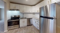 Located at 102 Fort Couch Rd in Bethel Park, PA, this single-floor unit offers a thoughtfully updated interior with a consistent, modern aesthetic throughout. The kitchen stands out as a highlight, featuring crisp white cabinetry with gold-tone hardware, light stone-look countertops, a geometric tile backsplash, and a full suite of stainless steel appliances including a refrigerator, electric range, and dishwasher. Light wood-style flooring runs throughout the entire unit, providing a clean and cohesive look. The living areas are generously proportioned, offering ample room for flexible furniture arrangements. Natural light filters in through windows fitted with blinds and vertical shades, brightening the neutral warm-gray walls. Baseboard heating and wall-mounted AC units are present in the main living spaces for year-round comfort. The unit includes two bathrooms: one features wainscoting, light wood-look flooring, and a clean, functional layout with a toilet and storage; the other is a half-bath with a pedestal-style sink and granite-accented fixtures. The bedrooms are well-sized, each offering closet access and windows with natural light. The overall design is clean, neutral, and move-in ready, making this Bethel Park unit a practical and attractive space.