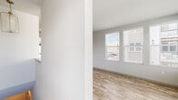 Located in Colorado Springs, CO, this well-designed one-bedroom, one-bathroom unit offers a clean, modern aesthetic with thoughtful finishes throughout. The open-concept kitchen and living area serves as the heart of the home, featuring light wood-style flooring, crisp white shaker cabinets, a subway tile backsplash, quartz countertops, stainless steel appliances, and a kitchen island with pendant lighting overhead. A stacked washer and dryer is conveniently tucked nearby. The living area is bathed in natural light through multiple large windows fitted with blinds, offering views of the surrounding neighborhood. The bedroom is carpeted and includes a ceiling fan and direct access to a generously sized walk-in closet complete with built-in shelving, hanging rods, and a window for added brightness. The full bathroom features wood-style flooring, a vanity with a white countertop, and a glass-enclosed walk-in shower with tile surround. Neutral gray tones, recessed lighting, and consistent finishes create a cohesive and contemporary ambiance throughout the entire space.