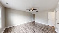 Located at 3340 Richlands Hwy in Jacksonville, NC, this two-story home offers five bedrooms, two full bathrooms, and two kitchens spread across two well-proportioned floors. The main level sets a clean, neutral tone with light gray walls, white trim, and durable luxury vinyl plank flooring that flows throughout. The kitchen stands out with crisp white shaker-style cabinetry, stone-look countertops, black appliances including a range, dishwasher, and microwave, and a window that brings in natural light. Both bathrooms are finished in a consistent neutral palette, with one featuring a tub-shower combo and a small window above for ventilation. Bedrooms are bright and comfortable, with several featuring ceiling fans with lighting, large windows fitted with blinds, and plush carpeting. The generously sized primary bedroom includes ample square footage and easy closet access. Additional bedrooms on the upper level mirror the same warm, carpeted feel, with windows providing natural light and closet space in select rooms. A dedicated laundry area with washer and dryer connections adds practicality. The home's consistent finishes, functional layout, and dual-kitchen configuration make it well-suited for flexible living arrangements.
