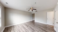 Located at 3340 Richlands Hwy in Jacksonville, NC, this two-story home offers five bedrooms, two full bathrooms, and two kitchens spread across two well-proportioned floors. The main level sets a clean, neutral tone with light gray walls, white trim, and durable luxury vinyl plank flooring that flows throughout. The kitchen stands out with crisp white shaker-style cabinetry, stone-look countertops, black appliances including a range, dishwasher, and microwave, and a window that brings in natural light. Both bathrooms are finished in a consistent neutral palette, with one featuring a tub-shower combo and a small window above for ventilation. Bedrooms are bright and comfortable, with several featuring ceiling fans with lighting, large windows fitted with blinds, and plush carpeting. The generously sized primary bedroom includes ample square footage and easy closet access. Additional bedrooms on the upper level mirror the same warm, carpeted feel, with windows providing natural light and closet space in select rooms. A dedicated laundry area with washer and dryer connections adds practicality. The home's consistent finishes, functional layout, and dual-kitchen configuration make it well-suited for flexible living arrangements.