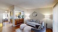 Located at 5016 Paseo Padre Parkway in Fremont, California, this two-story, one-bedroom, one-bathroom home offers a functional and thoughtfully arranged layout spread across two levels. The main living area on the upper floor combines a kitchen and living room in an open-concept design. The kitchen features light wood cabinetry, quartz-style countertops, a full suite of appliances including a dishwasher and electric range, and a skylight that draws in natural light. The adjacent living room is warm and inviting, finished with hardwood flooring and a sliding glass door that opens to a balcony offering pleasant outdoor views of the surrounding greenery. The bedroom is a comfortable retreat with hardwood floors, a mirrored sliding-door closet, and a sliding glass door that allows natural light to fill the space. A textured ceiling carries throughout the home, adding a consistent architectural detail. The bathroom is well-appointed with a tiled shower-tub combination, sliding glass enclosure, and a vanity with stone-style countertops. A staircase connects the two floors, with the entry level serving as a transitional foyer space. Overall, the home presents a clean, neutral palette with warm wood tones that create a cohesive and comfortable atmosphere throughout.